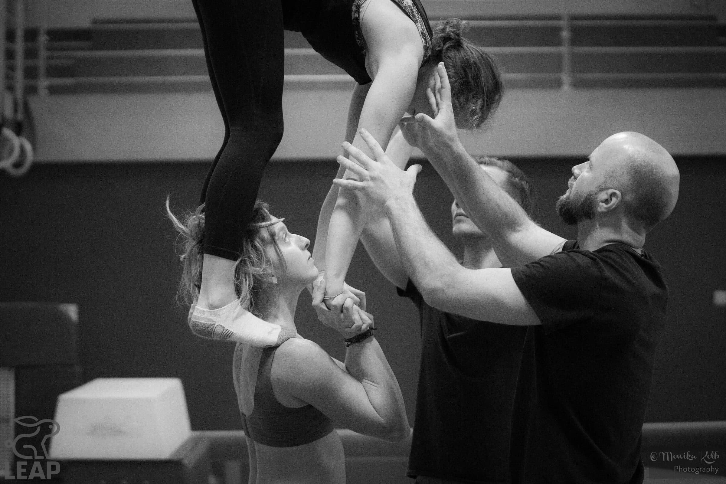 A coach spots a flyer as she comes down into her base's hands, in black and white