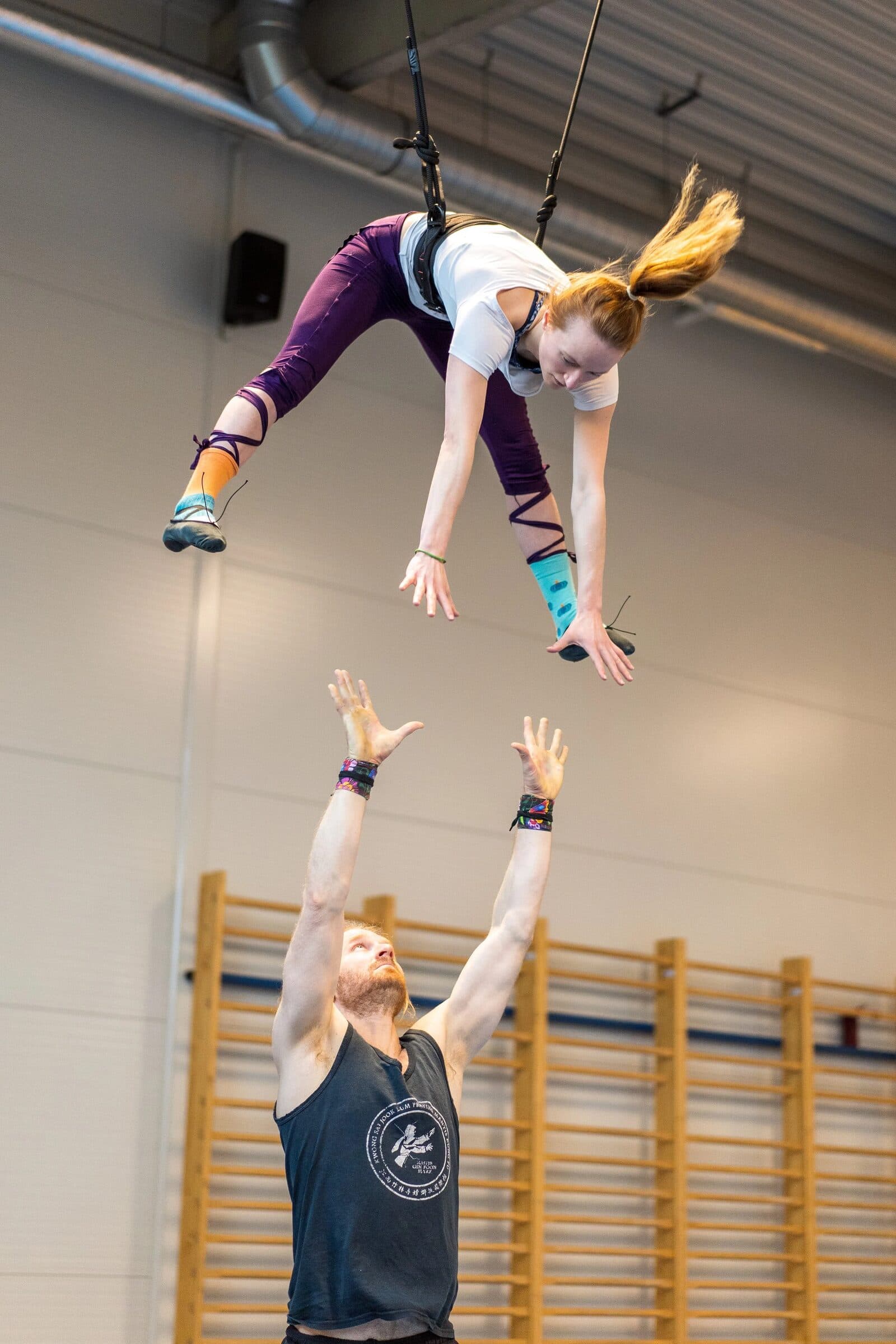 Tempo training in the gym, the flyer in the air on a safety lunge, the base ready to catch